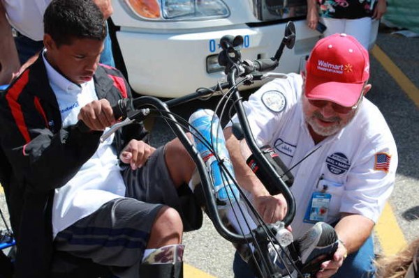 Devante Dupree, left, sits in his new modified tricycle Friday afternoon at the Mexico Walmart, as Wal-Mart Heart program volunteer John Lestage straps his feet into the pedals. Dupree, 13, of Mexico, was born with cerebral palsy. He was surprised Friday with a ride around town in a rig, the chair and other gifts. Devante Dupree, left, sits in his new modified tricycle Friday afternoon at the Mexico Walmart, as Wal-Mart Heart program volunteer John Lestage straps his feet into the pedals. Dupree, 13, of Mexico, was born with cerebral palsy. He was surprised Friday with a ride around town in a rig, the chair and other gifts.