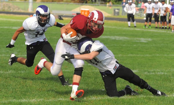Deering's Mike Marzilli (right) and Ricardo Delgado (left) can't stop Bangor's Logan Lanham as he rushes into the end zone to score during the first half of the game in Bangor on Saturday. Deering's Mike Marzilli (right) and Ricardo Delgado (left) can't stop Bangor's Logan Lanham as he rushes into the end zone to score during the first half of the game in Bangor on Saturday.