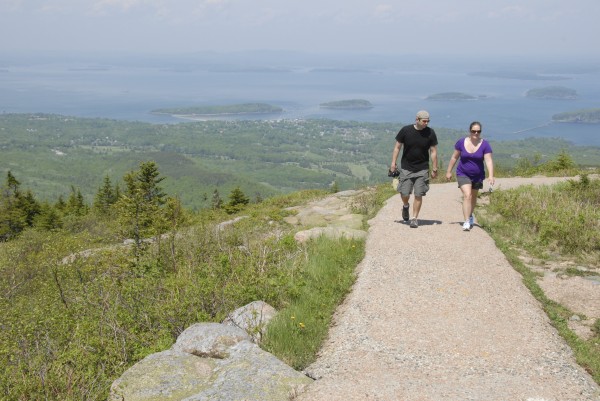 Taking advantage of the balmy temperatures, two tourists walk along the path that encircles the summit of Cadillac Mountain in Acadia National Park Saturday, June 1, 2012. Bar Harbor and the Porcupine Islands spread beyond the tourists. Taking advantage of the balmy temperatures, two tourists walk along the path that encircles the summit of Cadillac Mountain in Acadia National Park Saturday, June 1, 2012. Bar Harbor and the Porcupine Islands spread beyond the tourists.