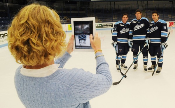 Laura Reid, University of Maine assistant athletic director for public relations, snaps a picture of UMaine hockey players Connor Leen, Andrew Tegeler and Andrew Cerretani during hockey media day at Orono on Monday. Laura Reid, University of Maine assistant athletic director for public relations, snaps a picture of UMaine hockey players Connor Leen, Andrew Tegeler and Andrew Cerretani during hockey media day at Orono on Monday.