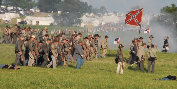 Confederate troops advance past “dead” or “wounded” Union soldiers during a battle re-enactment fought at Gettysburg, Penn. on July 4, 2013. During Civil War combat, casualties often vanished behind enemy lines if the other side won a particular fight; a soldier might be captured, killed, or wounded in such circumstances, but if his status remained unknown, his comrades and family considered him “missing in action.” Confederate troops advance past “dead” or “wounded” Union soldiers during a battle re-enactment fought at Gettysburg, Penn. on July 4, 2013. During Civil War combat, casualties often vanished behind enemy lines if the other side won a particular fight; a soldier might be captured, killed, or wounded in such circumstances, but if his status remained unknown, his comrades and family considered him “missing in action.”