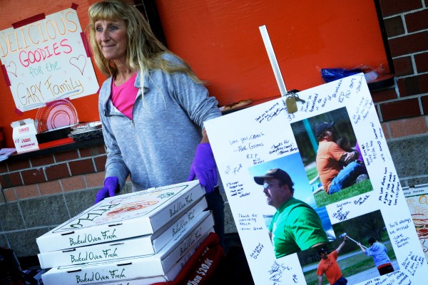Jo-Ellyn Sturgeon sells pizza and goodies at a football game in Brunswick Thursday, raising money for the Gary family. Football coach and Boy Scout leader Phil Gary, 45, died unexpectedly on Tuesday leaving eight children and his wife Gail. Jo-Ellyn Sturgeon sells pizza and goodies at a football game in Brunswick Thursday, raising money for the Gary family. Football coach and Boy Scout leader Phil Gary, 45, died unexpectedly on Tuesday leaving eight children and his wife Gail.