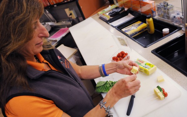 Registered dietitian Mary Lavanway at Hannaford assembles a cheese, basil and cherry tomato snack that she recommends for healthy weekend football tailgating. Registered dietitian Mary Lavanway at Hannaford assembles a cheese, basil and cherry tomato snack that she recommends for healthy weekend football tailgating.