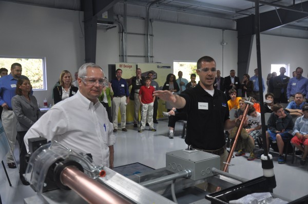 John Butera (left), Gov. Paul LePage's senior economic advisor, looks on as Nate Veilleux, a mechanical engineer at Mega Industries in Gorham, demonstrates to a room full of students how a piece of equipment designed by a summer intern from the University of Maine works. John Butera (left), Gov. Paul LePage's senior economic advisor, looks on as Nate Veilleux, a mechanical engineer at Mega Industries in Gorham, demonstrates to a room full of students how a piece of equipment designed by a summer intern from the University of Maine works.