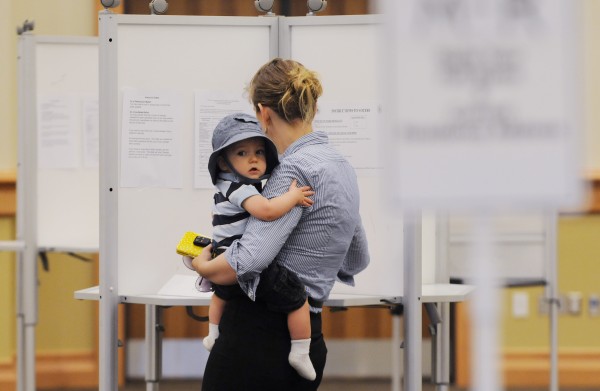 A voter marks her ballot with a child on her hip at Bangor's Cross Insurance Center in June. A voter marks her ballot with a child on her hip at Bangor's Cross Insurance Center in June.