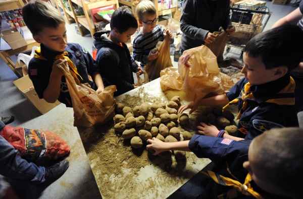 Boy Scouts from Pack 6 Bangor Wolf Den along with their siblings fill bags with potatoes in the basement of Manna on Saturday as Manna Ministries prepares to distribute Thanksgiving dinners to hundreds of needy families in the area on Monday. Boy Scouts from Pack 6 Bangor Wolf Den along with their siblings fill bags with potatoes in the basement of Manna on Saturday as Manna Ministries prepares to distribute Thanksgiving dinners to hundreds of needy families in the area on Monday.
