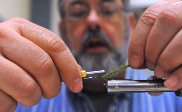 Hugh Kelly of Orono ties a fly he designed and calls "pretty young wife" at the Penobscot Fly Fishers Fly Tying Expo held at the Brewer Auditorium Sunday. Hugh Kelly of Orono ties a fly he designed and calls "pretty young wife" at the Penobscot Fly Fishers Fly Tying Expo held at the Brewer Auditorium Sunday.