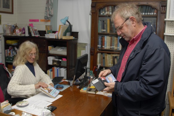 Weekly Photo by Brian Swartz
While checking out a children's book for his 7-year-old granddaughter on Nov. 16, David Richardson of Carmel searches for his library card as Library Director Becky Ames processes the book at the Simpson Memorial Library in Carmel. Weekly Photo by Brian Swartz
While checking out a children's book for his 7-year-old granddaughter on Nov. 16, David Richardson of Carmel searches for his library card as Library Director Becky Ames processes the book at the Simpson Memorial Library in Carmel.
