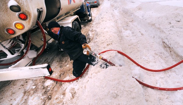 Greg Hamilton, a delivery driver with Dead River Co., struggles through a waist-high snow bank after filling the oil tank at a Brewer home Monday morning. Greg Hamilton, a delivery driver with Dead River Co., struggles through a waist-high snow bank after filling the oil tank at a Brewer home Monday morning.