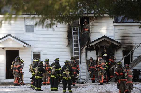Firefighters from Old Town and Orono stand by as other members of their crews finish putting out a fire on Main Street in Old Town on Friday. Firefighters from Old Town and Orono stand by as other members of their crews finish putting out a fire on Main Street in Old Town on Friday.