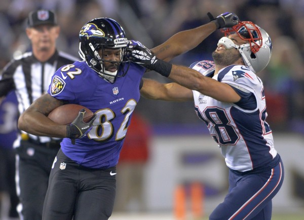 Baltimore Ravens wide receiver Torrey Smith provides a stiff arm to New England Patriots strong safety Steve Gregory after making a reception during the second half of their game in Baltimore on Sunday. Baltimore Ravens wide receiver Torrey Smith provides a stiff arm to New England Patriots strong safety Steve Gregory after making a reception during the second half of their game in Baltimore on Sunday.