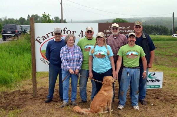 Farm for ME supporters gathered last spring to erect a sign identifying the program site. Joining in the celebration were (from left) Frank Beaulieu, neighbor and Farm for ME steering committee member; Martie Pritchard, landowner; Jim Krysiak, Catholic Charities warehouse manager; Dixie Shaw, Catholic Charities program director; Jim Pritchard, landowner; Jeff Tiner, Catholic Charities chief operations officer; Chip Beckwith, Casella Organics field rep and Farm for ME steering committee member; and Bright, the golden retriever. Farm for ME supporters gathered last spring to erect a sign identifying the program site. Joining in the celebration were (from left) Frank Beaulieu, neighbor and Farm for ME steering committee member; Martie Pritchard, landowner; Jim Krysiak, Catholic Charities warehouse manager; Dixie Shaw, Catholic Charities program director; Jim Pritchard, landowner; Jeff Tiner, Catholic Charities chief operations officer; Chip Beckwith, Casella Organics field rep and Farm for ME steering committee member; and Bright, the golden retriever.