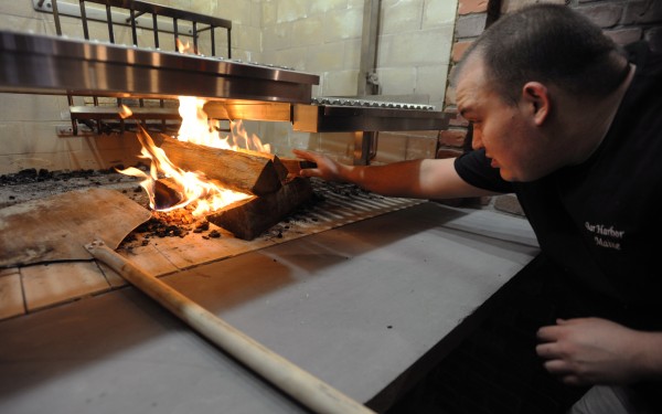 Grill Chef Jeff Russell lights a wood fire in the grill as Blaze, Bangor's newest restaurant, plans a soft opening for Tuesday with a grand opening on Friday. Grill Chef Jeff Russell lights a wood fire in the grill as Blaze, Bangor's newest restaurant, plans a soft opening for Tuesday with a grand opening on Friday.