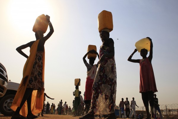 In this January 2014 file photo, displaced people carry water containers on their heads at Tomping camp. Some 15,000 displaced people who fled their homes from this camp are sheltered by the United Nations, near South Sudan's capital Juba. In this January 2014 file photo, displaced people carry water containers on their heads at Tomping camp. Some 15,000 displaced people who fled their homes from this camp are sheltered by the United Nations, near South Sudan's capital Juba.
