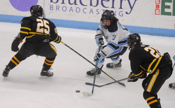 The University of Maine's Ryan Lomberg (center) battles for the puck with American International's Carson Grolla (left) and David Norris during a game on Dec. 13, 2013, in Orono. The University of Maine's Ryan Lomberg (center) battles for the puck with American International's Carson Grolla (left) and David Norris during a game on Dec. 13, 2013, in Orono.