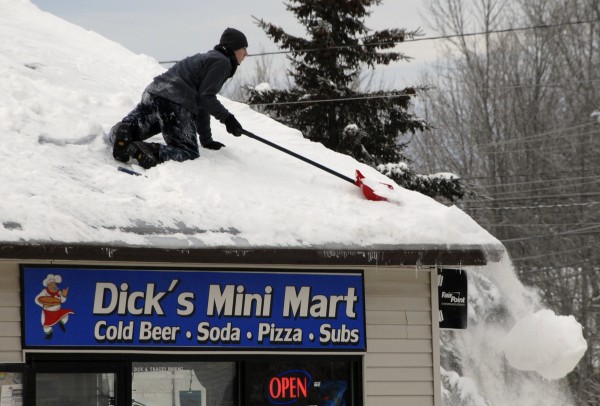 Taking advantage of the 10-degree temperature and dry weather on Jan. 4, Joshua Burris pushes a large shovelful of snow off the roof of Dick's Mini Mart at the intersection of Routes 2 and 69 in Carmel Village. Burris said that he had spent the previous day shoveling off most of the roof; finishing the job took about 45 minutes on Saturday. Taking advantage of the 10-degree temperature and dry weather on Jan. 4, Joshua Burris pushes a large shovelful of snow off the roof of Dick's Mini Mart at the intersection of Routes 2 and 69 in Carmel Village. Burris said that he had spent the previous day shoveling off most of the roof; finishing the job took about 45 minutes on Saturday.