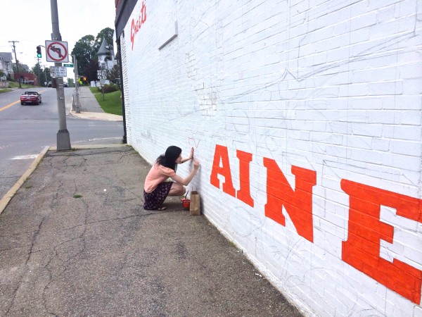Kristen Hart, 21, of Newburgh, paints the "M" in "Greetings from Bangor, Maine" on a mural designed by Annette Dodd, co-owner of the Rock and Art Shop in Bangor, on July 25, 2014, on the wall of the brick building at 152 Main Street in downtown Bangor, which houses the Main Tavern. Kristen Hart, 21, of Newburgh, paints the "M" in "Greetings from Bangor, Maine" on a mural designed by Annette Dodd, co-owner of the Rock and Art Shop in Bangor, on July 25, 2014, on the wall of the brick building at 152 Main Street in downtown Bangor, which houses the Main Tavern.