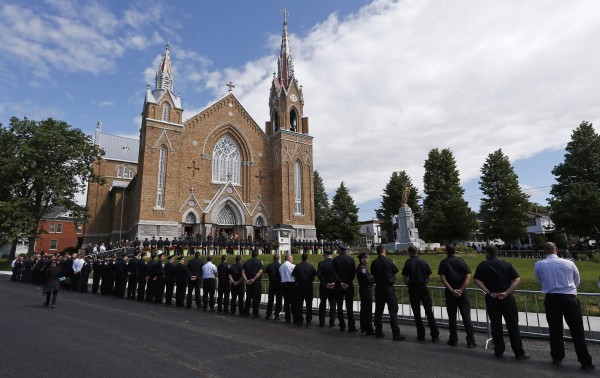 Emergency responders form an honor guard prior to a memorial mass at the Sainte-Agnes church in Lac-Megantic, July 6, 2014. The mass was held to commemorate the first anniversary of the crude-oil train explosion that killed 47 people on the morning of July 6, 2013. Emergency responders form an honor guard prior to a memorial mass at the Sainte-Agnes church in Lac-Megantic, July 6, 2014. The mass was held to commemorate the first anniversary of the crude-oil train explosion that killed 47 people on the morning of July 6, 2013.