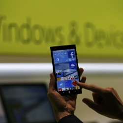 A Microsoft representative shows a smartphone with Windows 10 operating system at the CeBIT trade fair in Hanover, Germany. March 15, 2015. REUTERS/Morris Mac Matzen
