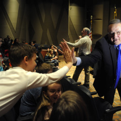 Gov. Paul LePage high-fives third-grader Tyler Alexander as he exits the performing arts center after signing LD 1609 into law at the Brewer Community School, April 4, 2016. 