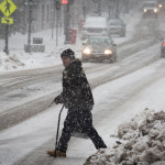 A man looks up Congress Street while crossing in the snow on Thursday. Much of the state could see as much as two feet of snow as a strong winter storm moves in Sunday afternoon into Tuesday morning.