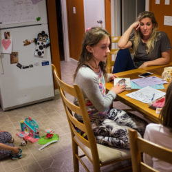 Megan Stover sits at the kitchen table after dinner with her three daughters (from left) Andie, 5, Madison, 10, and Nellie, 7, at their home in Scarborough.