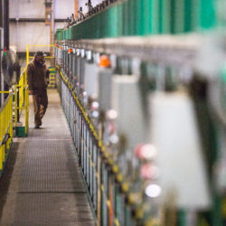 A worker at Robbins Lumber in Searsmont monitors equipment on a recent rainy winter day.